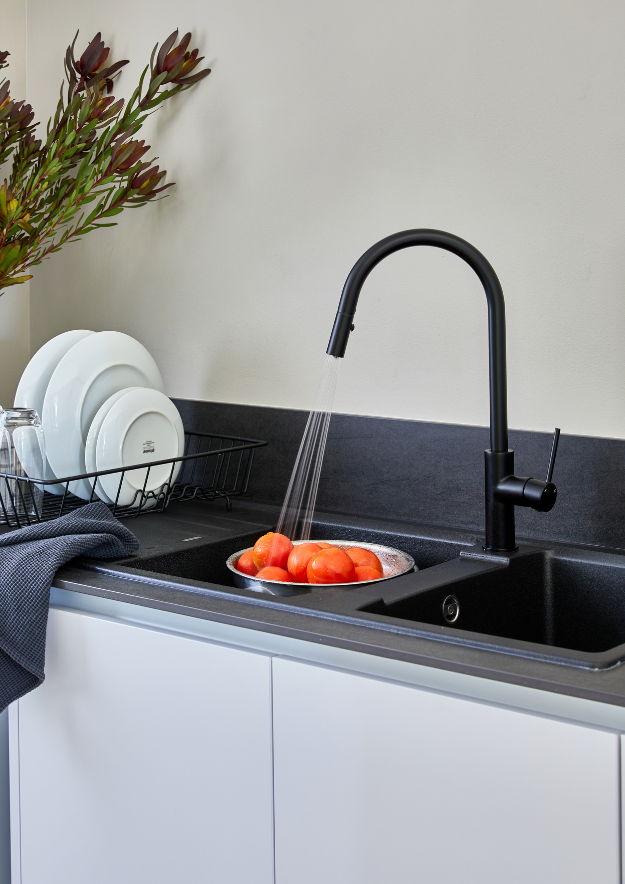 Matt black pull-down kitchen mixer above a double sink